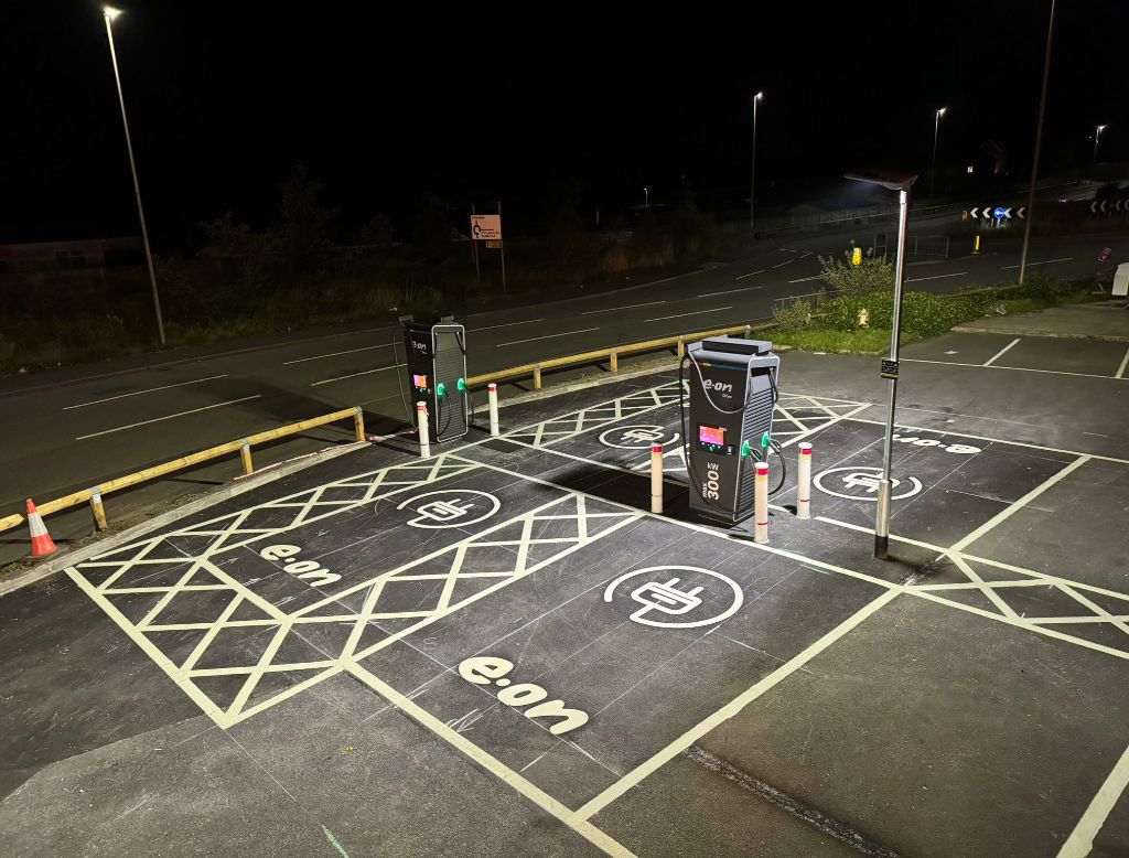 Cross Hands EV charging bays at night — e.on branded bay markings and 300kW chargers illuminated